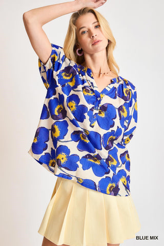 Woman wearing a blue floral blouse with a white background